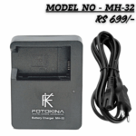 Black FOTOKINA MH-32 battery charger and AC power cable for digital cameras, showing the battery slot and price tag of RS 699.
