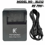 A black FOTOKINA BLC12 Digital Camera Battery Charger, designed for BLC12 batteries, shown next to its black AC power cable with a 2-pin European/Indian plug. The text overlays read "MODEL NO - BLC12" and "RS 799/-".